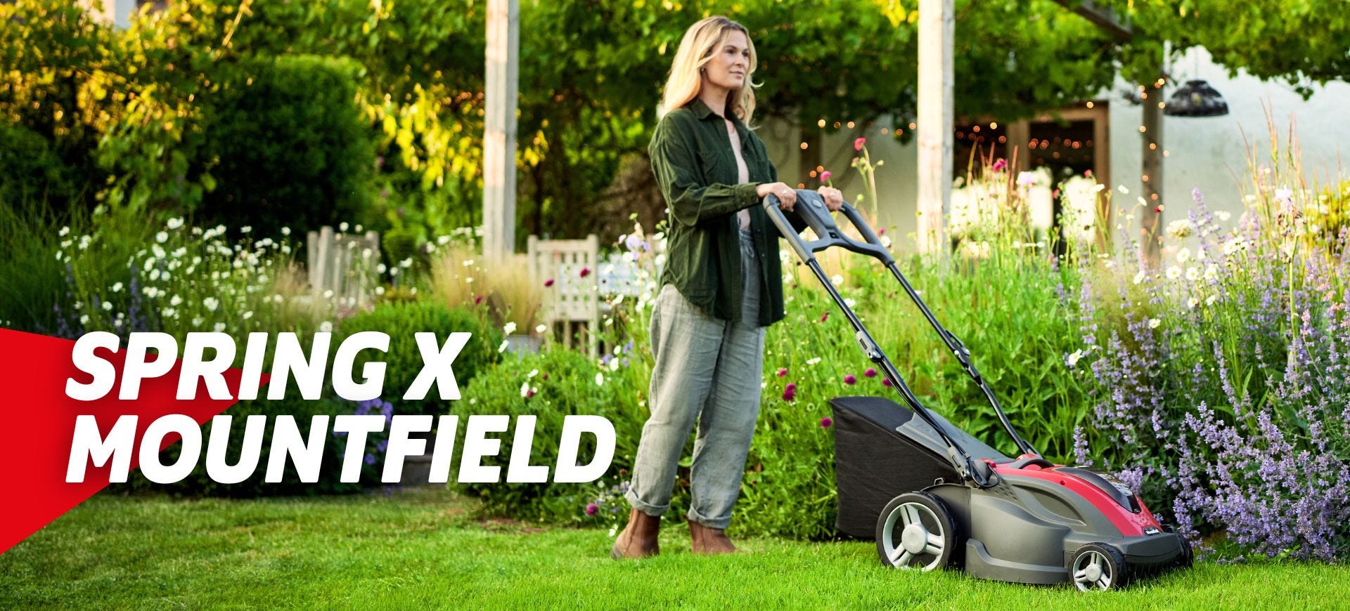 Woman pushing mountfield lawnmower in spring garden